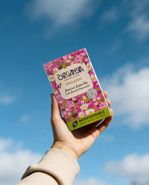Organsia Jasmine Green Tea carton against a blue sky